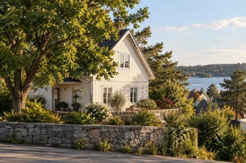 Vitt hus bakom en stenmur en solig sommardag